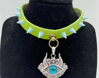 Blue Daemon Eye On A Green Choker With Blue Spikes