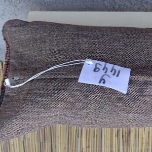 May include: A brown pillow with a white tag that says "5441 C".