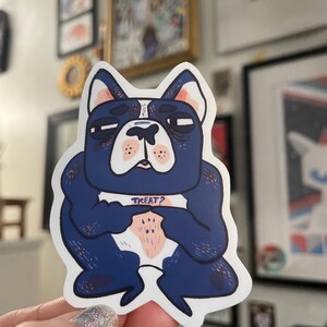 Könnte beinhalten: Ein blauer und weißer Cartoon-Aufkleber eines französischen Bulldoggen mit dem Text "TREAT?" auf seiner Brust.