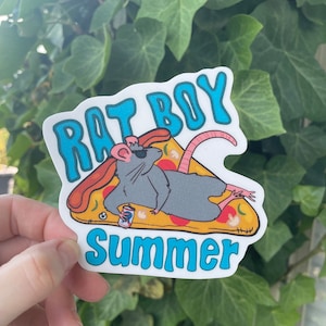 May include: A white sticker with a cartoon rat wearing sunglasses and lying on a slice of pizza. The rat is holding a can of soda. The text "Rat Boy Summer" is written in blue letters on the sticker.
