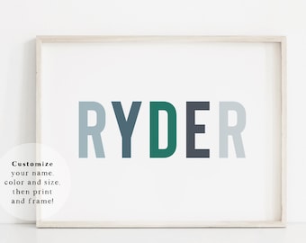 May include: A framed print with the name "RYDER" in large, bold letters. Each letter is a different color: light blue, dark blue, green, black, and gray.