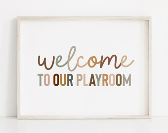 May include: A framed print with the text "welcome to our playroom" in a variety of muted colours, including brown, beige, and green.