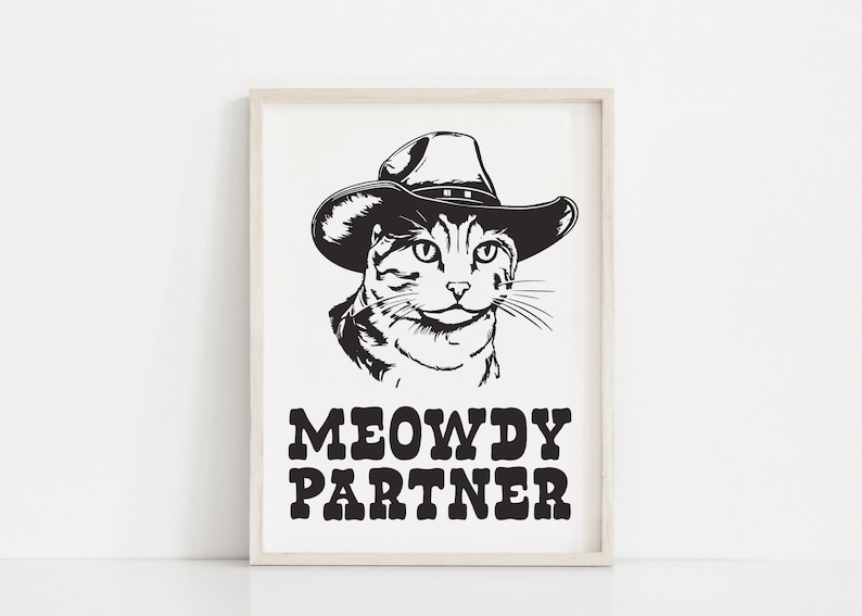 Pu&ograve; includere: Illustrazione in bianco e nero di un gatto con un cappello da cowboy. Il gatto guarda direttamente lo spettatore. Il testo "MEOWDY PARTNER" &egrave; sotto il gatto.