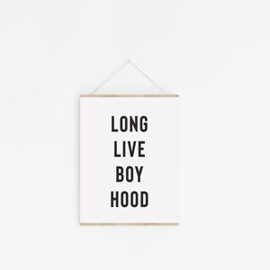 May include: A white framed print with the text "LONG LIVE BOY HOOD" in black lettering.