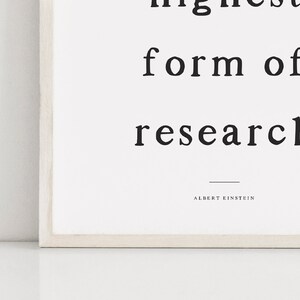 May include: Black and white typography print with the quote "The highest form of research is to question everything" by Albert Einstein.