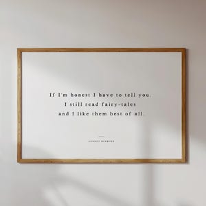 May include: A framed print with a light wood frame. The print features the quote, "If I'm honest I have to tell you. I still read fairy-tales and I like them best of all." The quote is in a simple, elegant font.