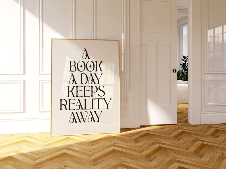May include: A white poster with black text that reads "A book a day keeps reality away" hanging on a white wall in a room with a wooden floor.