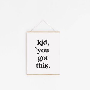May include: A white framed print with black text that reads "kid, you got this."