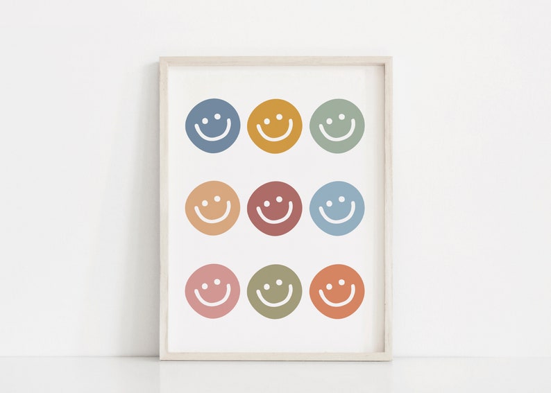 May include: A framed print with nine colorful smiley faces in various shades of blue, green, yellow, orange, and red. The smiley faces are arranged in three rows of three.