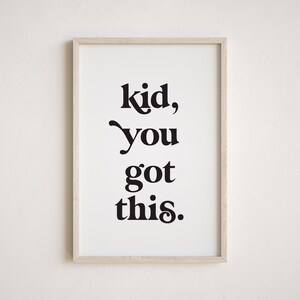 May include: A framed print with the text "kid, you got this." in black bold font on a white background.