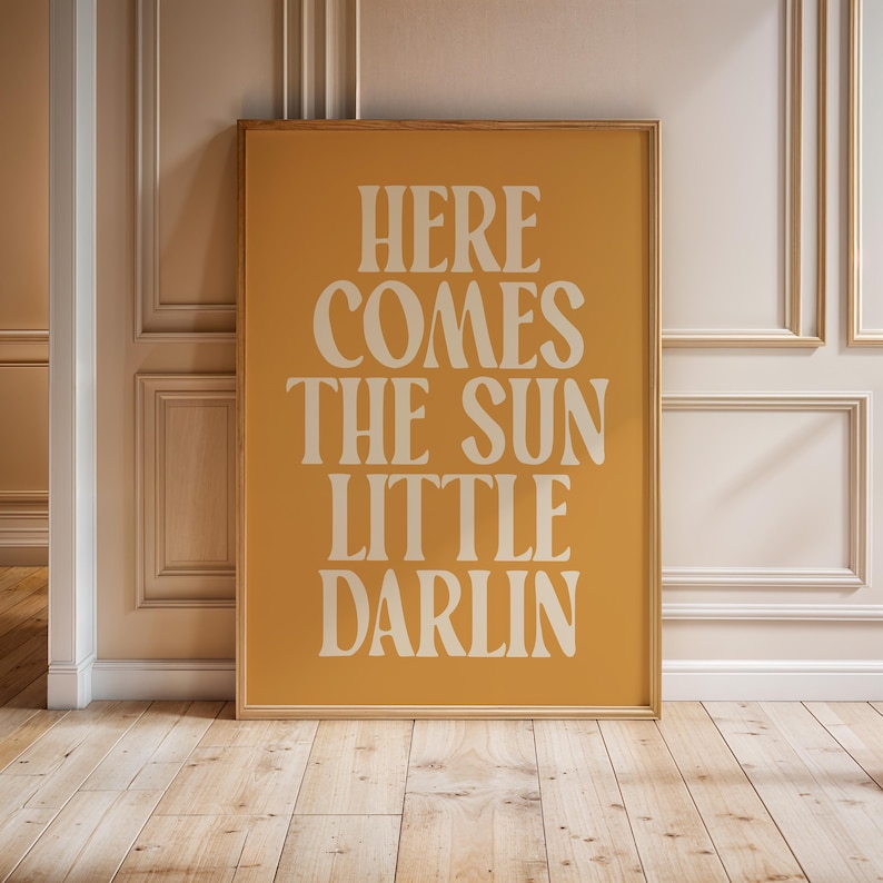 K&ouml;nnte beinhalten: Ein gelber Poster mit dem Text "Here comes the sun little darlin" in wei&szlig;en Buchstaben.