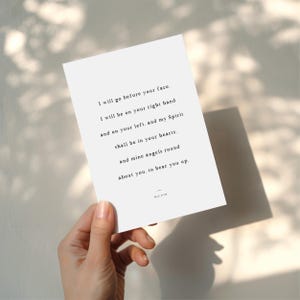 K&ouml;nnte beinhalten: Eine wei&szlig;e Karte mit schwarzem Text wird von einer Hand gehalten. Der Text enth&auml;lt die S&auml;tze &bdquo;Ich gehe vor deinem Angesicht her&ldquo; und &bdquo;meine Engel rings um dich&ldquo;. Die Karte hat ein minimalistisches Design und ist wahrscheinlich ein Druck oder ein Kunstwerk.
