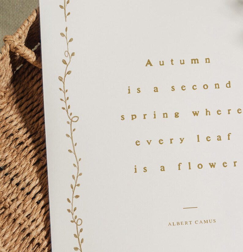 May include: A cream-colored card with gold text that reads "Autumn is a second spring where every leaf is a flower" by Albert Camus. A gold floral design runs along the left edge.