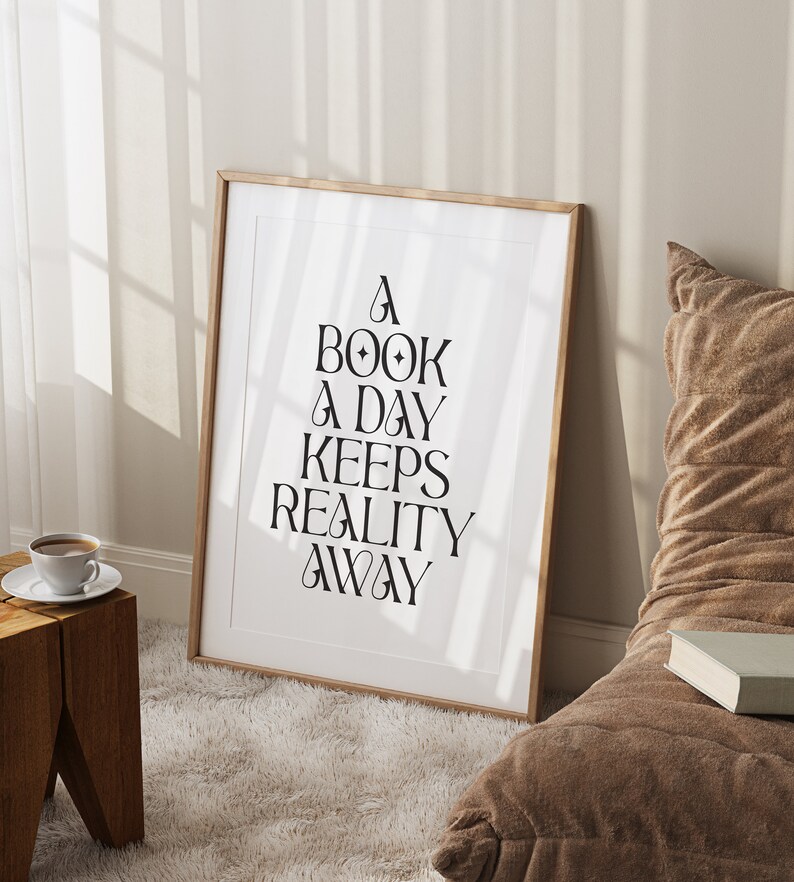 May include: A framed print with the text "A book a day keeps reality away" in black lettering on a white background.
