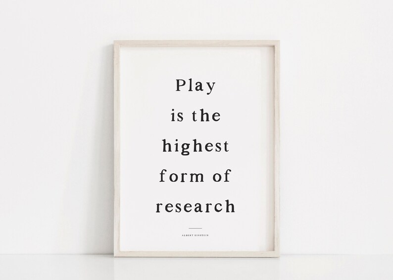 May include: A framed print with a white background and black text that reads "Play is the highest form of research." The text is attributed to Albert Einstein.