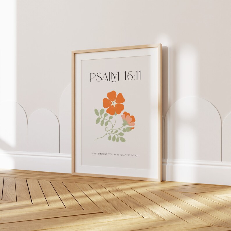 K&ouml;nnte beinhalten: Gerahmter Kunstdruck mit dem Text "PSALM 16:11" &uuml;ber einer floralen Illustration mit orangefarbenen und rosa Bl&uuml;ten und gr&uuml;nen Bl&auml;ttern. Der untere Teil des Drucks lautet "IN HIS PRESENCE THERE IS FULLNESS OF JOY". Der Rahmen ist aus hellem Holz.
