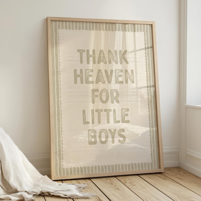 Puede incluir: Impresi&oacute;n enmarcada con el texto "THANK HEAVEN FOR LITTLE BOYS" en fuente verde claro. La impresi&oacute;n tiene un fondo beige claro con un borde verde claro y est&aacute; en un marco de madera clara.