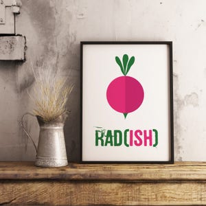 Op de afbeelding: Een witte ingelijste print met een roze radijs illustratie en de tekst "RAD[ISH]" in groen.