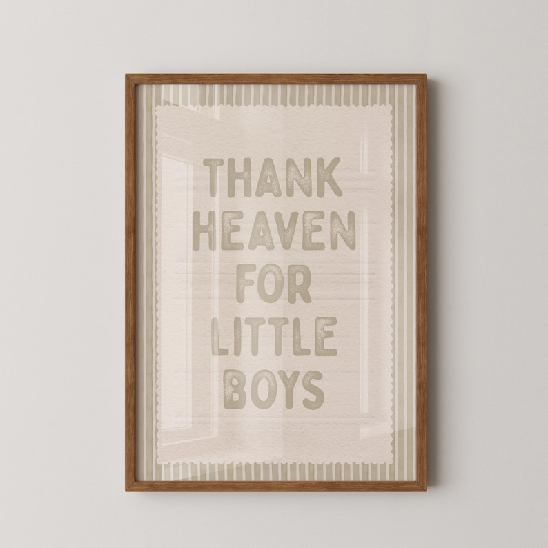 Puede incluir: Un estampado enmarcado con el texto "THANK HEAVEN FOR LITTLE BOYS" en una fuente marr&oacute;n claro. El estampado tiene un fondo beige con un borde decorativo y est&aacute; encerrado en un marco de madera marr&oacute;n.