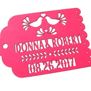 Puede incluir: Corte de papel rosa con un dise&ntilde;o decorativo que presenta dos p&aacute;jaros, un motivo floral y el texto "DONNA & ROBERT 08.26.2017".