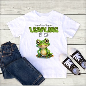 May include: White t-shirt with a green frog illustration and the text "Toad-ally a Leapling Est 2020".