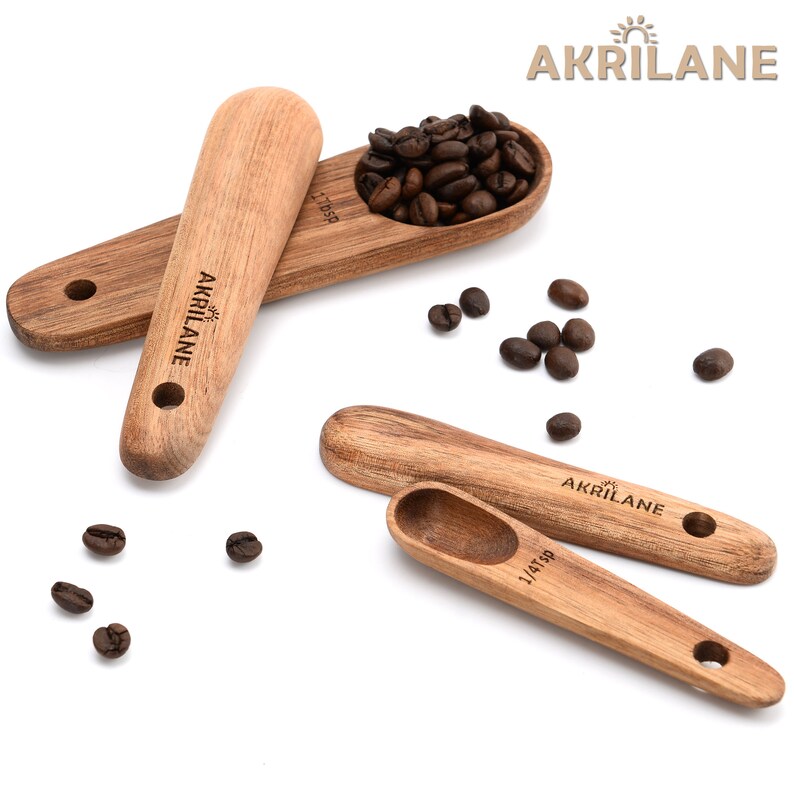 May include: Set of four wooden spoons with measurements for scooping coffee beans. The spoons are made of natural wood and have the brand name "AKRILANE" engraved on them.