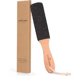 May include: A black pumice stone foot file with a wooden handle. The handle has the text "AKRILANE" and a sun logo. The product comes in a brown cardboard box with the text "PUMICE STONE CALLUS REMOVER PREMIUM QUALITY" and "AKRILANE 100% Natural".