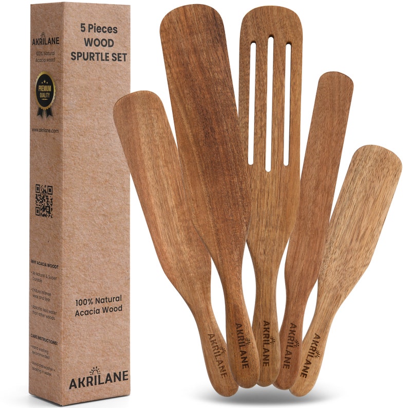 May include: Set of five wooden spatulas made from acacia wood. The spatulas are brown and have a natural wood finish. Each spatula has the word "AKRILANE" printed on the handle.