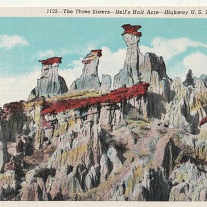 May include: A vintage postcard depicting "The Three Sisters" rock formations in Hell's Half Acre, Wyoming. The postcard features a colorful landscape with red, white, and blue rock formations.