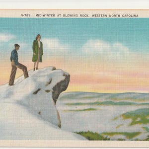 May include: A vintage postcard titled MID-WINTER AT BLOWING ROCK, WESTERN NORTH CAROLINA, featuring a snowy cliffside with two figures standing on the edge, overlooking a vast, hazy mountain valley under a soft, pastel-colored winter sky.