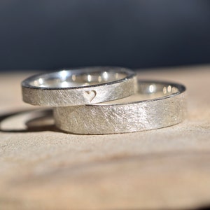 Simple silver wedding rings with an engraved heart