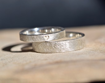 Simple silver wedding rings with an engraved heart