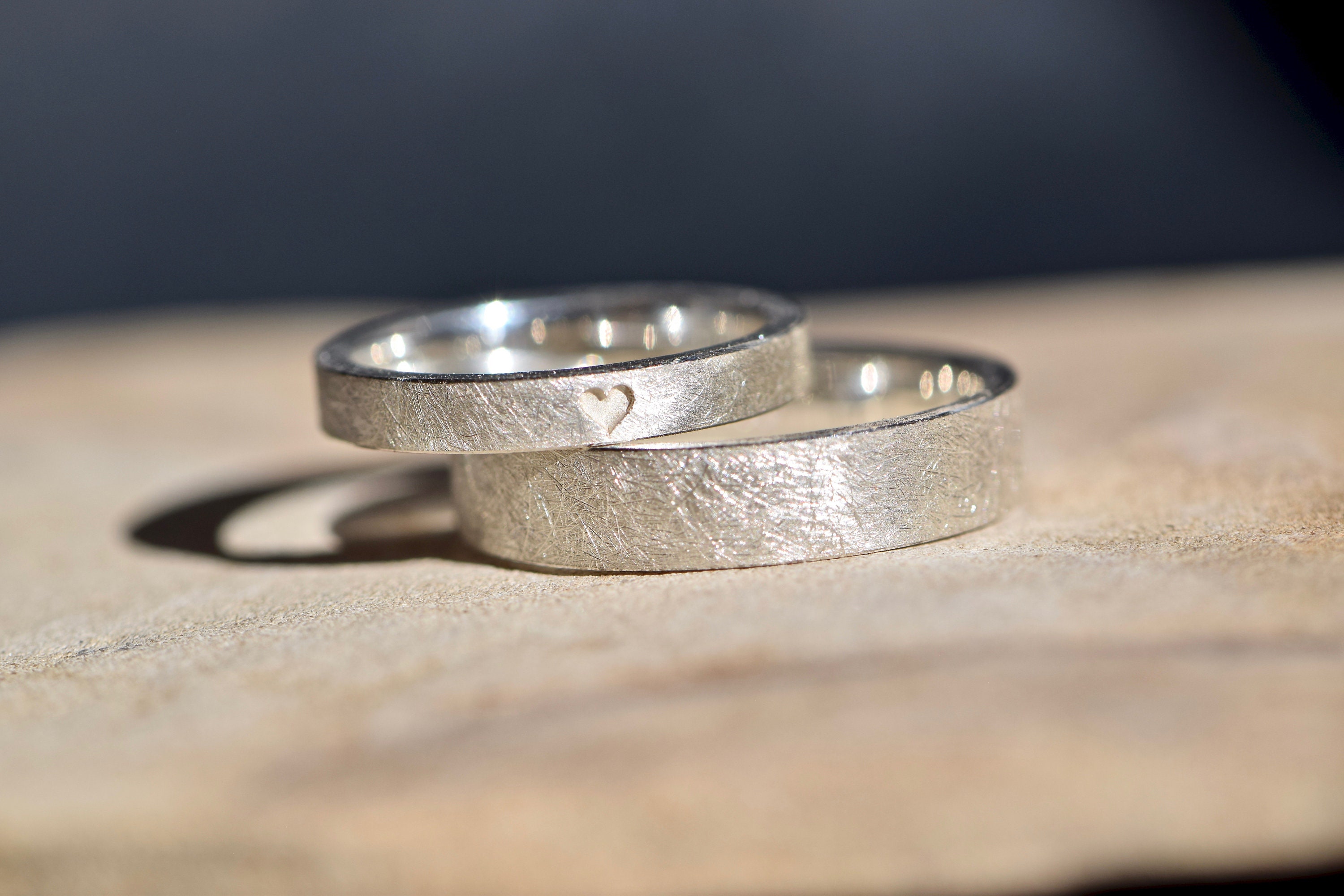 Simple silver wedding rings with an engraved heart