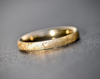Gold engagement ring with heart engraving and matte surface