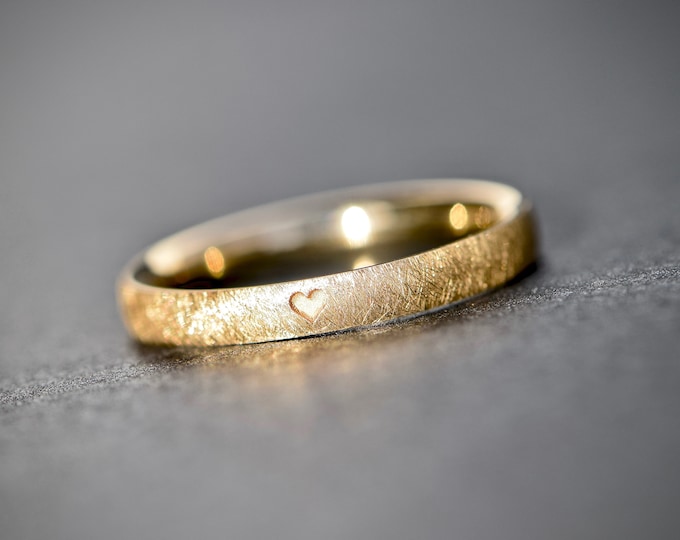 Gold engagement ring with heart engraving and matte surface