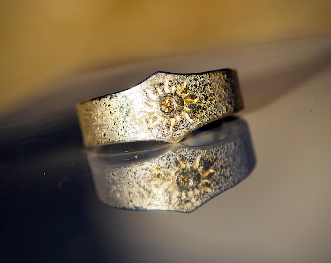 A talisman ring with a hand-stamped sun, yellow brilliant-cut diamond, and gold dust – unique energy and protection