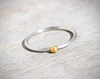 Delicate silver stacking ring with solid 900 yellow gold bead – minimalist handmade atelier entry ring