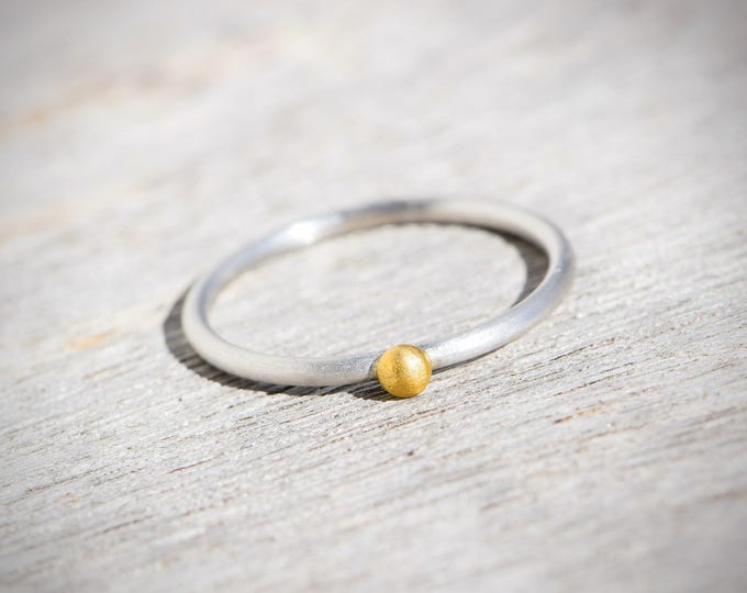 Delicate silver stacking ring with solid 900 yellow gold bead – minimalist handmade atelier entry ring