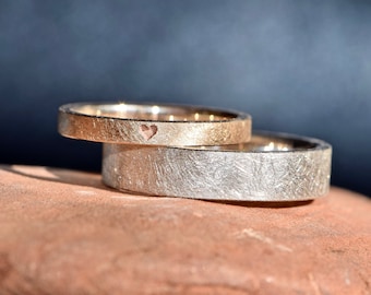 Simple wedding rings made of rose gold and silver with engraved heart