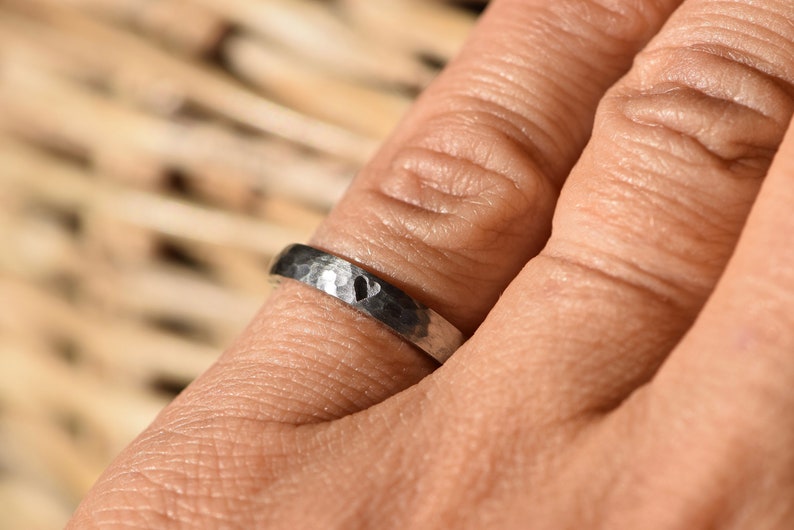 May include: A silver hammered band ring with a heart design.