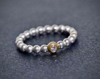 Ball ring made of silver and gold with white diamonds