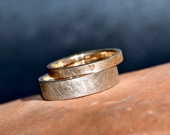 Simple wedding bands in rose and white gold with an engraved heart