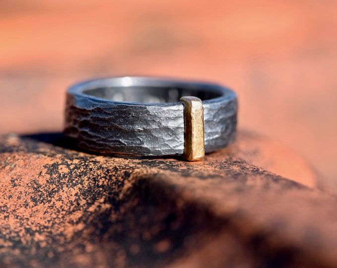 Black ring made of silver hammered with red gold