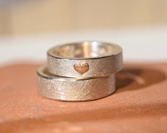 Wedding rings handmade from silver with a rose gold heart
