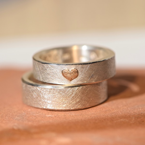 Wedding rings handmade from silver with a rose gold heart