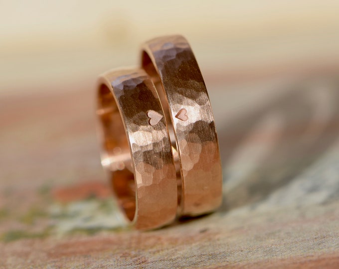 Wedding rings hammered from red gold with heart