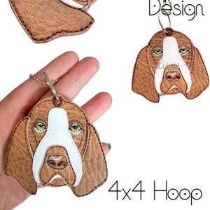 May include: Digital embroidery design of a brown and white Bloodhound dog head with a key chain loop. The design is for a 4x4 hoop.