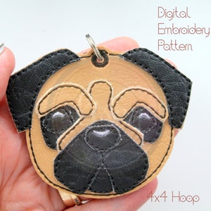 May include: A digital embroidery pattern for a pug face keychain, designed for a 4x4 hoop. The pattern features a tan pug face with black ears, nose, and eyes.