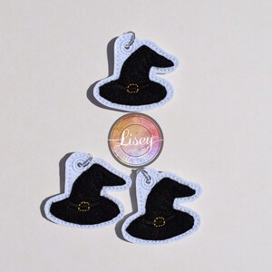 May include: Three black witch hats with gold buckles and white outlines. The hats are on a white background.  "Lisey Designs" is written in a circle with a rainbow gradient.