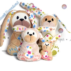 Peut inclure: Quatre jouets en peluche en forme de lapin de différentes tailles. Le plus grand lapin est brun avec des oreilles à fleurs blanches et bleues. Le deuxième plus grand lapin est beige avec des oreilles à fleurs blanches et bleues. Le lapin suivant est rose avec des oreilles à fleurs blanches et bleues. Le plus petit lapin est vert avec des oreilles à fleurs blanches et bleues.
